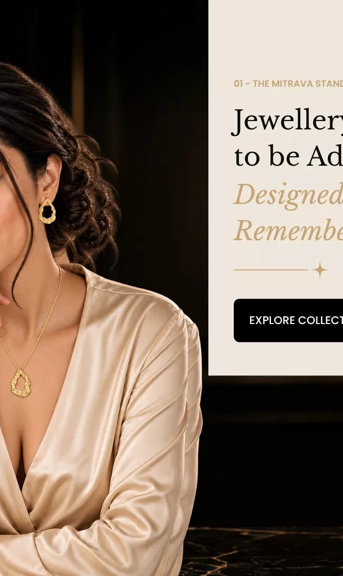 Luxury gold-plated jewellery worn by a woman in an elegant cream outfit, showcasing Mitrava jewellery in a sophisticated boutique setting.